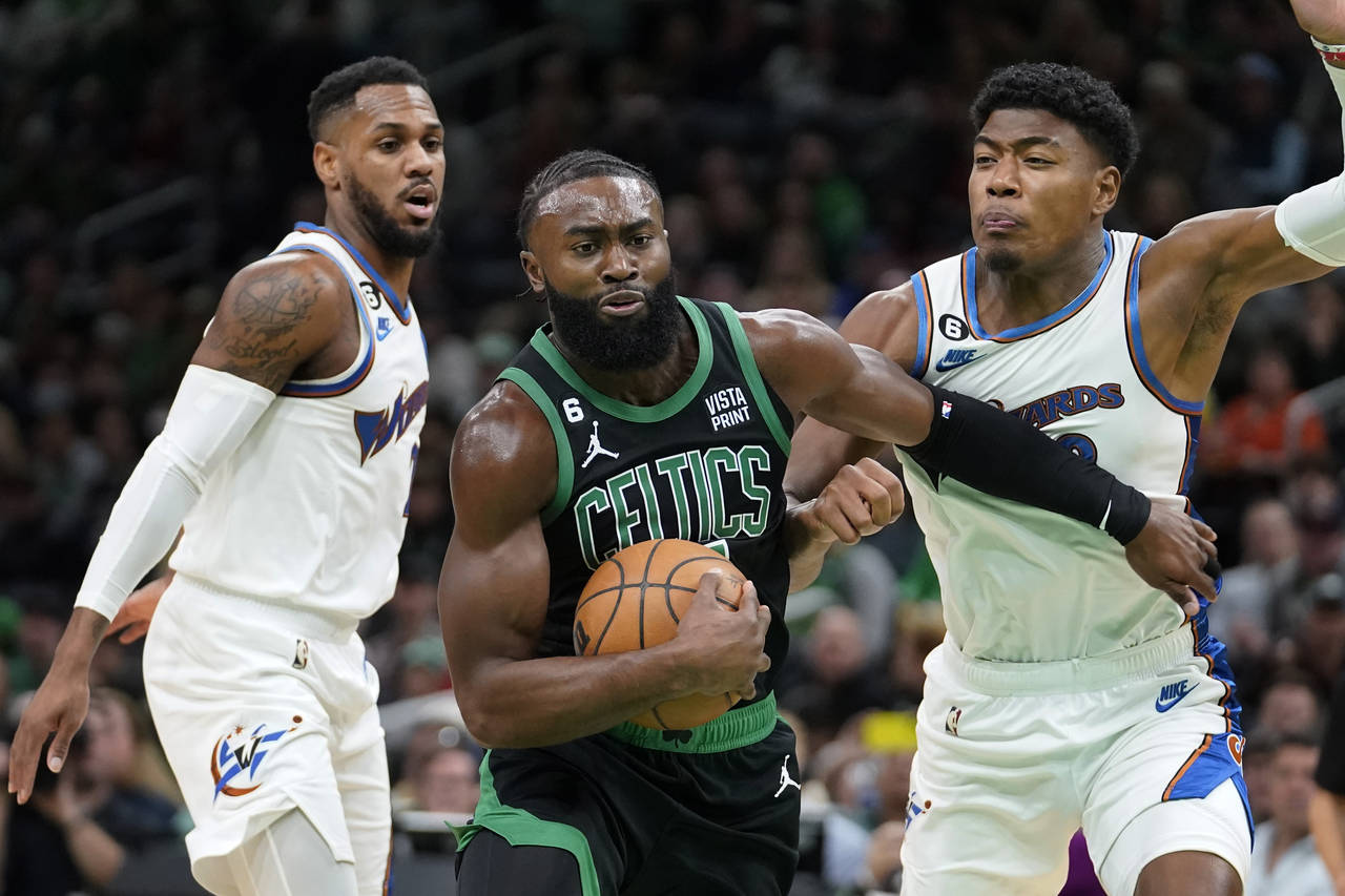 Boston Celtics guard Jaylen Brown, center, vies for control of the ball with Washington Wizards gua...
