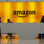 
              FILE - People stand in the lobby of Amazon offices on Feb. 14, 2019, in New York. A Maryland judge struck down the nation's first tax on digital advertising as unconstitutional on Monday, Oct. 17, 2022, a law that attorneys for Big Tech have contended unfairly targets companies like Amazon, Facebook and Google in a separate federal case against the same law.   (AP Photo/Mark Lennihan, File)
            