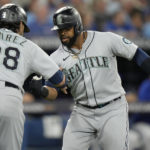 
              Seattle Mariners designated hitter Carlos Santana, right, celebrates after his three-run home run with teammate Eugenio Suarez (28) during the sixth )inning of Game 2 of a baseball AL wild-card playoff series against the Toronto Blue Jays, Saturday, Oct. 8, 2022, in Toronto. (Frank Gunn/The Canadian Press via AP)
            