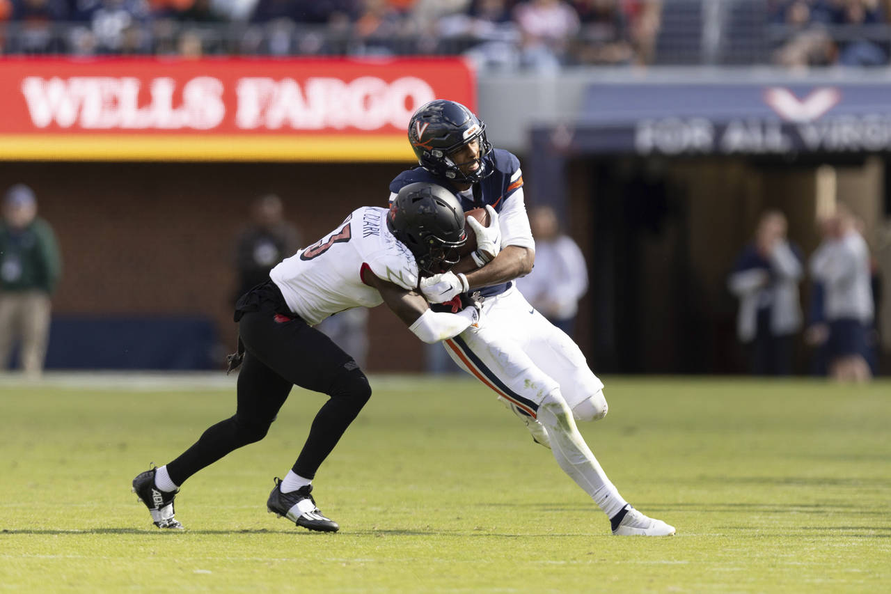 Virginia's Demick Starling, right, is tackled Virginia's Kei'Trel Clark during an NCAA college foot...