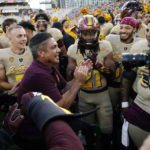 
              Arizona State interim head coach Shaun Aguano, front left, celebrates with players, including RJ Regan (21), after an NCAA college football game against Washington in Tempe, Ariz., Saturday, Oct. 8, 2022. (AP Photo/Ross D. Franklin)
            