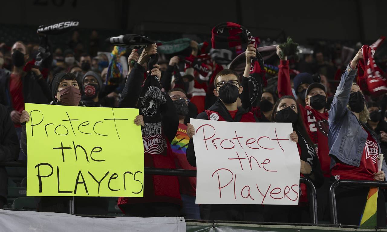 FILE - Portland Thorns fans hold signs during the first half of the team's NWSL soccer match agains...