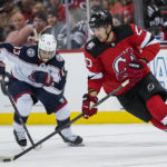 
              New Jersey Devils' Michael McLeod (20) skates with the puck around Columbus Blue Jackets left wing Johnny Gaudreau (13) during the third period of an NHL hockey game Sunday, Oct. 30, 2022, in Newark, N.J. (AP Photo/Eduardo Munoz Alvarez)
            