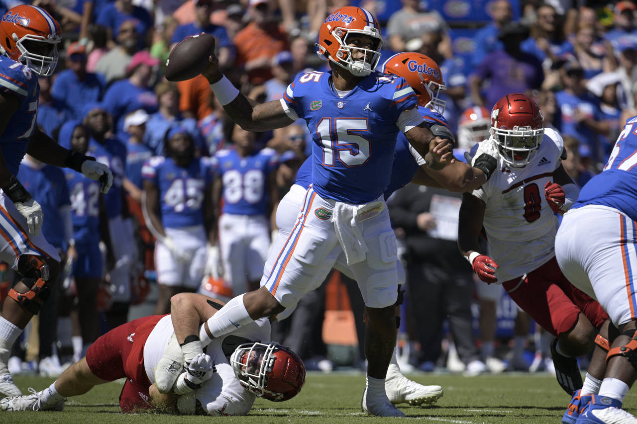 Florida quarterback Anthony Richardson (15) throws a pass for a completion while under pressure fro...