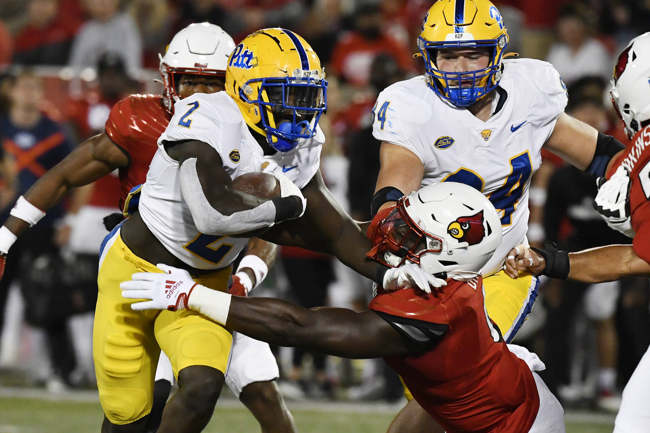 Pittsburgh running back Israel Abanikanda (2) attempts to get away from the grasp of Louisville def...