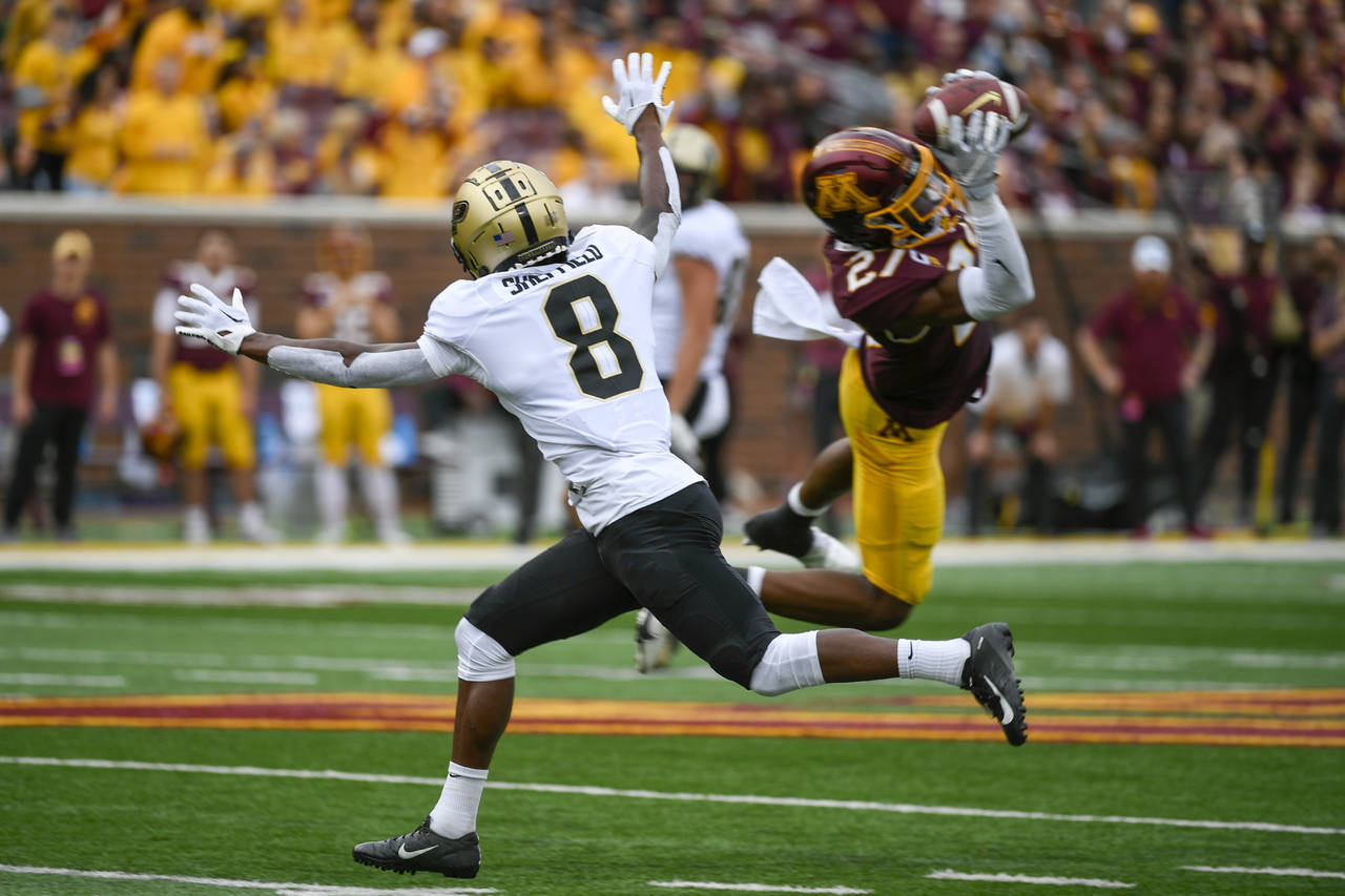 Minnesota defensive back Tyler Nubin, right, intercepts a pass intended for Purdue wide receiver TJ...