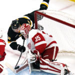 
              Boston Bruins center Charlie Coyle dives forward on a shot from behind Detroit Red Wings goaltender Ville Husso (35) during the first period of an NHL hockey game, Thursday, Oct. 27, 2022, in Boston. (AP Photo/Charles Krupa)
            