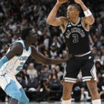 
              San Antonio Spurs' Keldon Johnson (3) looks to pass as he is defended by Charlotte Hornets' J.T. Thor during the second half of an NBA basketball game, Wednesday, Oct. 19, 2022, in San Antonio. Charlotte won 129-102. (AP Photo/Darren Abate)
            