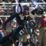 
              Houston Texans wide receiver Nico Collins (12) catches a pass as Jacksonville Jaguars cornerback Tyson Campbell (32) defends during the second half of an NFL football game in Jacksonville, Fla., Sunday, Oct. 9, 2022. (AP Photo/Phelan M. Ebenhack)
            