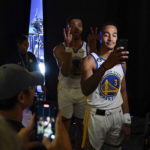 
              Golden State Warriors guard Quinndary Weatherspoon, background, photo bombs Jordan Poole's (3) video recording during an NBA basketball media day in San Francisco, Sunday, Sept. 25, 2022. (AP Photo/Godofredo A. Vásquez)
            