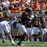 
              Oklahoma State's Dominic Richardson (20) takes a handoff from Spencer Sanders (3) during the first half of an NCAA college football game against Texas Tech in Stillwater, Okla., Saturday Oct. 8, 2022. (AP Photo/Mitch Alcala)
            