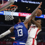 
              LA Clippers forward Paul George (13) defends against Houston Rockets guard Kevin Porter Jr. (3) during the second half of an NBA basketball game in Los Angeles, Monday, Oct. 31, 2022. (AP Photo/Ashley Landis)
            