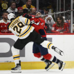 
              Washington Capitals right wing Garnet Hathaway collides with Boston Bruins defenseman Derek Forbort (28) during the first period of an NHL hockey game Wednesday, Oct. 12, 2022, in Washington. (AP Photo/Nick Wass)
            