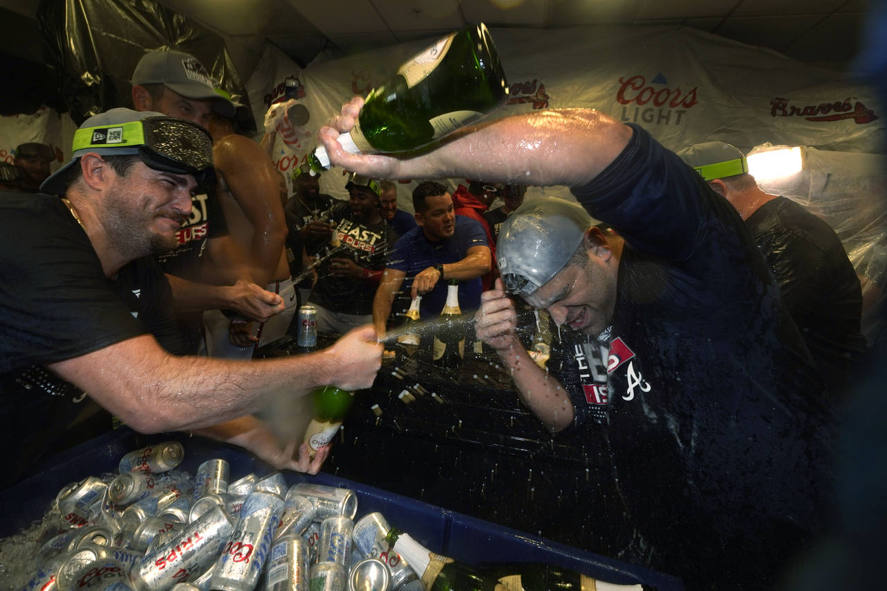 Atlanta Braves players celebrate in the club house after they clinched their fifth consecutive NL E...