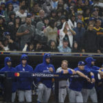 
              Members of the Los Angeles Dodgers look on from the dugout during the ninth inning in Game 4 of a baseball NL Division Series against the San Diego Padres, Saturday, Oct. 15, 2022, in San Diego. (AP Photo/Ashley Landis)
            