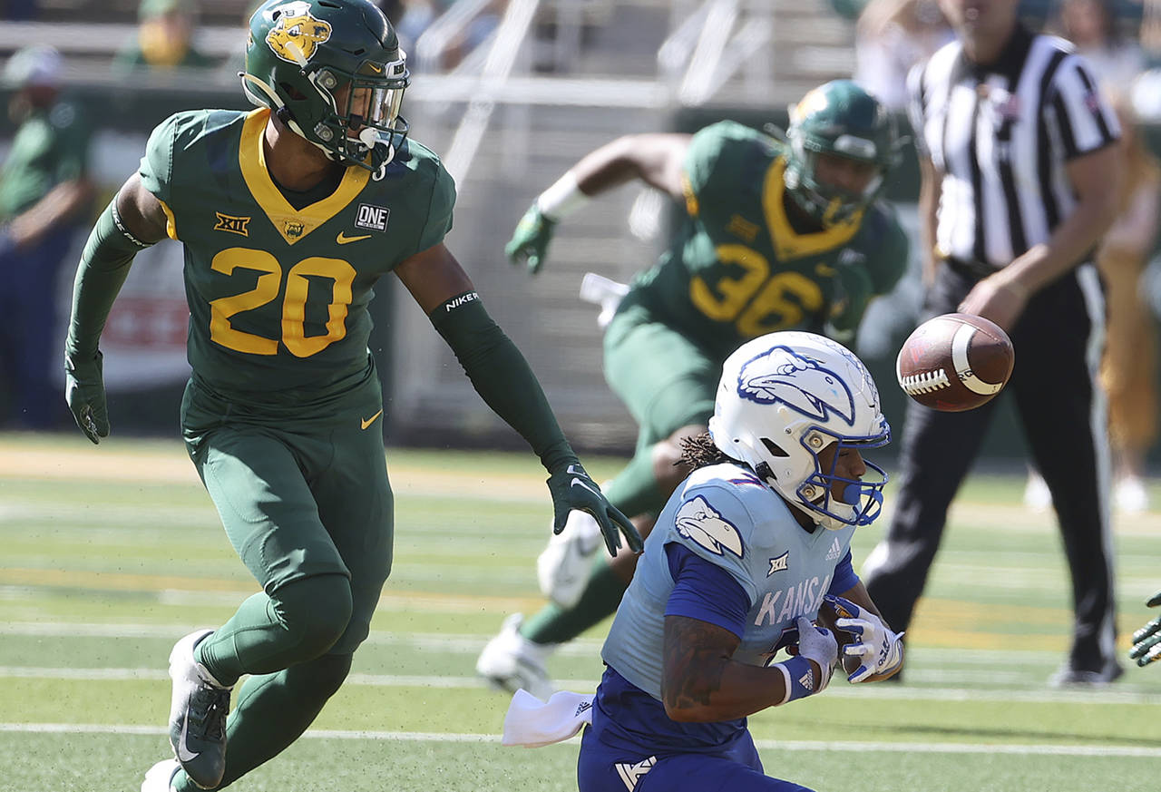 Kansas wide receiver Trevor Wilson attempts to catch the ball as Baylor safety Devin Lemear closes ...