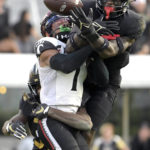 
              Central Florida cornerback Brandon Adams, left, and defensive back Divaad Wilson, right, break up a pass intended for Cincinnati wide receiver Tre Tucker (1) during the second half of an NCAA college football game, Saturday, Oct. 29, 2022, in Orlando, Fla. (AP Photo/Phelan M. Ebenhack)
            