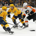 
              Philadelphia Flyers' Wade Allison (57) tries to control the puck as he is defended by Nashville Predators' Mark Borowiecki (90) and Tanner Jeannot (84) in the first period of an NHL hockey game Saturday, Oct. 22, 2022, in Nashville, Tenn. (AP Photo/Mark Humphrey)
            