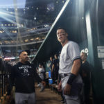 
              New York Yankees' Aaron Judge stands in the dugout after his solo home run during the first inning in the second baseball game of the team's doubleheader against the Texas Rangers in Arlington, Texas, Tuesday, Oct. 4, 2022. With the home run, Judge set the AL record for home runs in a season at 62, passing Roger Maris. (AP Photo/LM Otero)
            