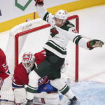 
              Minnesota Wild's Matt Boldy (12) collides with Montreal Canadiens goaltender Jake Allen during the second period of an NHL hockey game, Tuesday, Oct. 25, 2022 in Montreal. (Graham Hughes/The Canadian Press via AP)
            