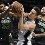 
              San Antonio Spurs' Zach Collins, center, tangles with Minnesota Timberwolves' Karl-Anthony Towns (32) and Kyle Anderson during the first half of an NBA basketball game, Sunday, Oct. 30, 2022, in San Antonio. (AP Photo/Darren Abate)
            
