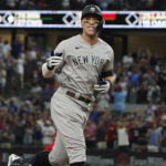
              New York Yankees' Aaron Judge gestures as he rounds the bases after hitting a solo home run, his 62nd of the season, during the first inning in the second baseball game of a doubleheader against the Texas Rangers in Arlington, Texas, Tuesday, Oct. 4, 2022. With the home run, Judge set the AL record for home runs in a season, passing Roger Maris.(AP Photo/LM Otero)
            