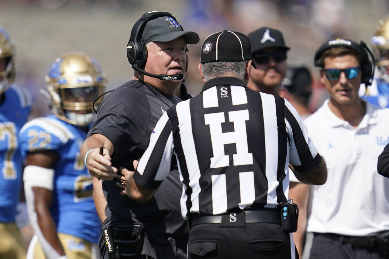 UCLA head coach Chip Kelly talks with an official during the first half of an NCAA college football...
