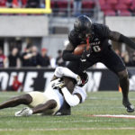 
              Wake Forest defensive back DaShawn Jones, bottom, grabs the leg of Louisville wide receiver Chris Bell, top, during the second half of an NCAA college football game in Louisville, Ky., Saturday, Oct. 29, 2022. (AP Photo/Timothy D. Easley)
            
