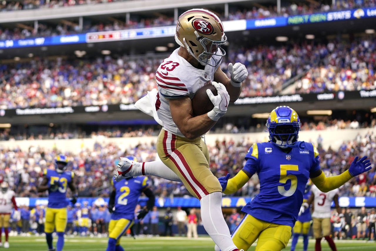 San Francisco 49ers running back Christian McCaffrey, center, comes down after making a touchdown c...