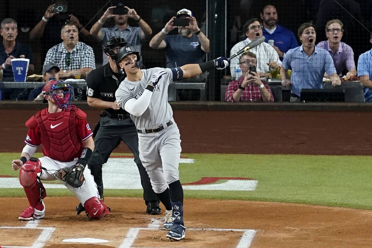 New York Yankees' Aaron Judge follows through on a solo home run, his 62nd of the season, as Texas ...
