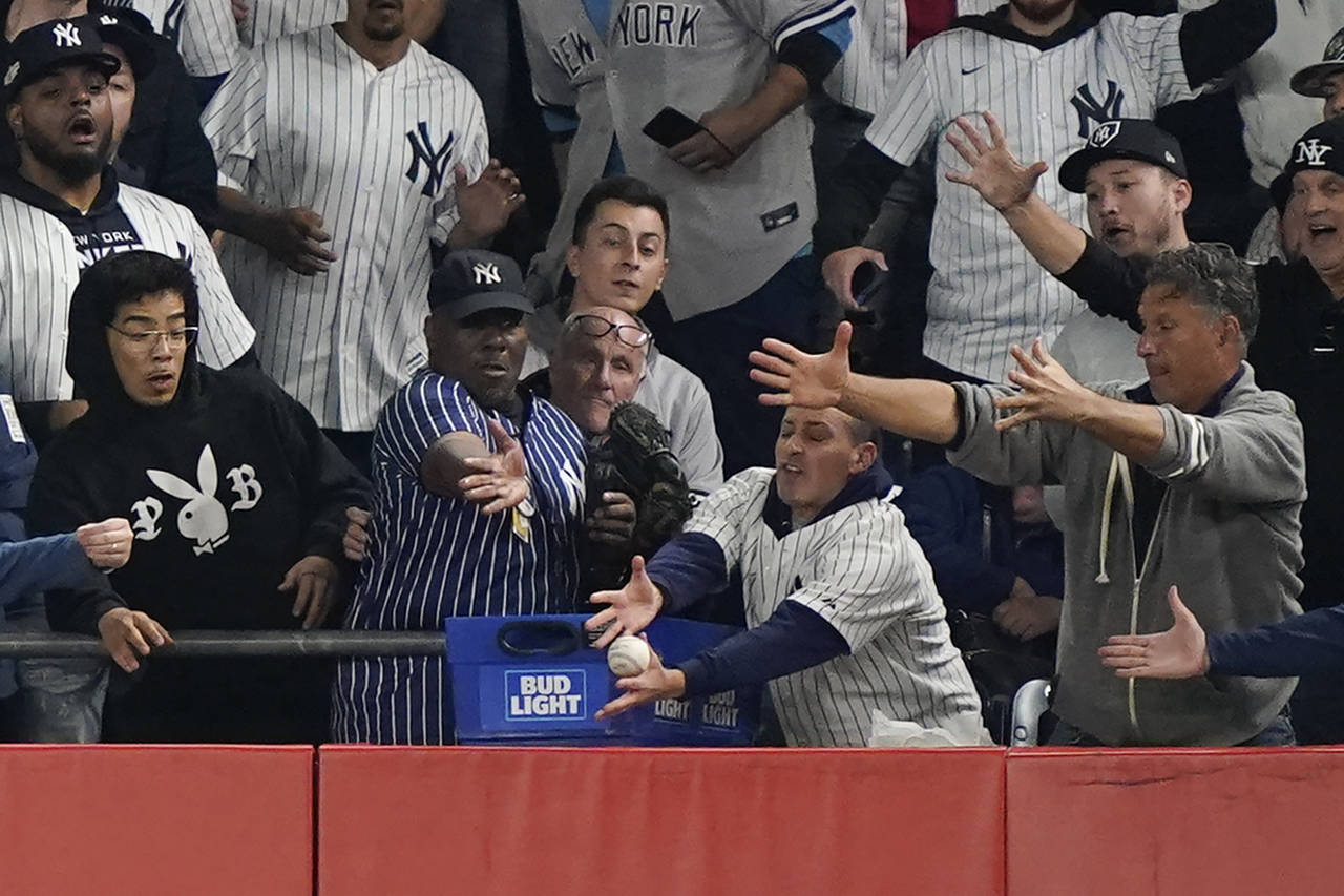 Fans reach for a ball hit by New York Yankees Josh Donaldson as it bounces off the top of the wall ...