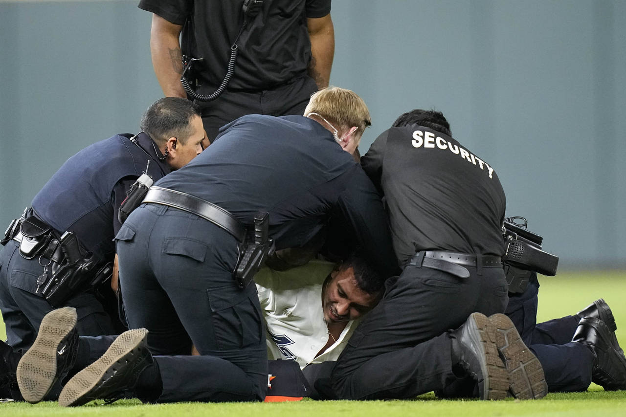 Security remove a fan on the field in between the eighth and ninth innings in Game 2 of baseball's ...