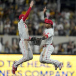 
              Philadelphia Phillies shortstop Bryson Stott celebrates with second baseman Jean Segura after their win against the San Diego Padres after Game 1 of the baseball NL Championship Series between the San Diego Padres and the Philadelphia Phillies on Tuesday, Oct. 18, 2022, in San Diego. (AP Photo/Gregory Bull)
            