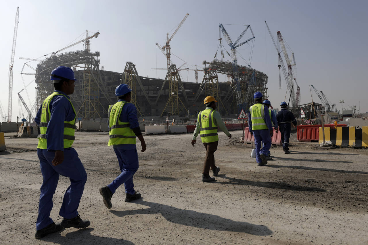 FILE - Workers walk to the Lusail Stadium, one of the 2022 World Cup stadiums, in Lusail, Qatar, Fr...