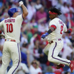 
              Philadelphia Phillies J.T. Realmuto (10) celebrates with Philadelphia Phillies Jean Segura (2) after Realmuto's RBI-single during the sixth inning in Game 4 of baseball's National League Division Series between the Philadelphia Phillies and the Atlanta Braves, Saturday, Oct. 15, 2022, in Philadelphia. (AP Photo/Matt Rourke)
            