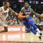 
              New York Knicks forward Julius Randle (30) drives against Cleveland Cavaliers forward Evan Mobley (4) during the second half of an NBA basketball game, Sunday, Oct. 30, 2022, in Cleveland. (AP Photo/Nick Cammett)
            