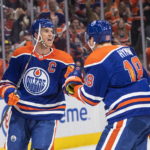 
              Edmonton Oilers' Connor McDavid (97) and Zach Hyman (18) celebrate a goal against the Vancouver Canucks during the second period of an NHL hockey game Wednesday, Oct. 12, 2022, in Edmonton, Alberta. (Jason Franson/The Canadian Press via AP)
            