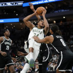 
              Milwaukee Bucks' Giannis Antetokounmpo, middle, drives to the basket against Brooklyn Nets' Patty Mills (8) during the second half of an NBA preseason basketball game Wednesday, Oct. 12, 2022, in Milwaukee. (AP Photo/Aaron Gash)
            