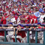
              Fans cheer behind the dugout during the ninth inning in Game 4 of baseball's National League Division Series between the Philadelphia Phillies and the Atlanta Braves, Saturday, Oct. 15, 2022, in Philadelphia. (AP Photo/Matt Slocum)
            