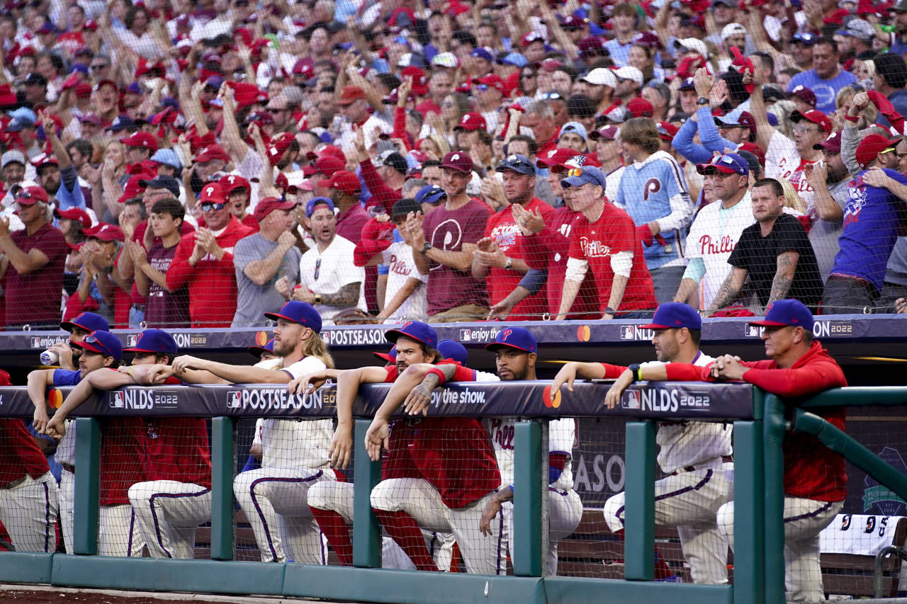 Fans cheer behind the dugout during the ninth inning in Game 4 of baseball's National League Divisi...