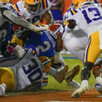 
              Florida running back Montrell Johnson Jr. (2) pushes past LSU linebacker Greg Penn III (30) and safety Joe Foucha (13) for a touchdown during the first half of an NCAA college football game, Saturday, Oct. 15, 2022, in Gainesville, Fla. (AP Photo/John Raoux)
            