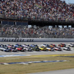 
              Driver Christopher Bell (20) leads the field to start a NASCAR Cup Series auto race Sunday, Oct. 2, 2022, in Talladega, Ala. (AP Photo/Butch Dill)
            