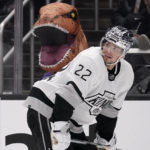 
              A fan wearing a dinosaur costume sits in the stands as Los Angeles Kings left wing Kevin Fiala skates by during the second period of an NHL hockey game against the Toronto Maple Leafs Saturday, Oct. 29, 2022, in Los Angeles. (AP Photo/Mark J. Terrill)
            