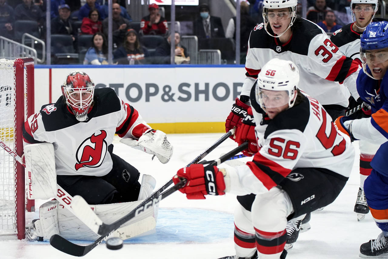 New Jersey Devils goaltender Mackenzie Blackwood (29) watches as left wing Erik Haula (56) reaches ...