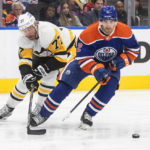 
              Pittsburgh Penguins' Jeff Carter (77) chases Edmonton Oilers' Evan Bouchard (2) during third-period NHL hockey game action in Edmonton, Alberta, Monday, Oct. 24, 2022. (Jason Franson/The Canadian Press via AP)
            