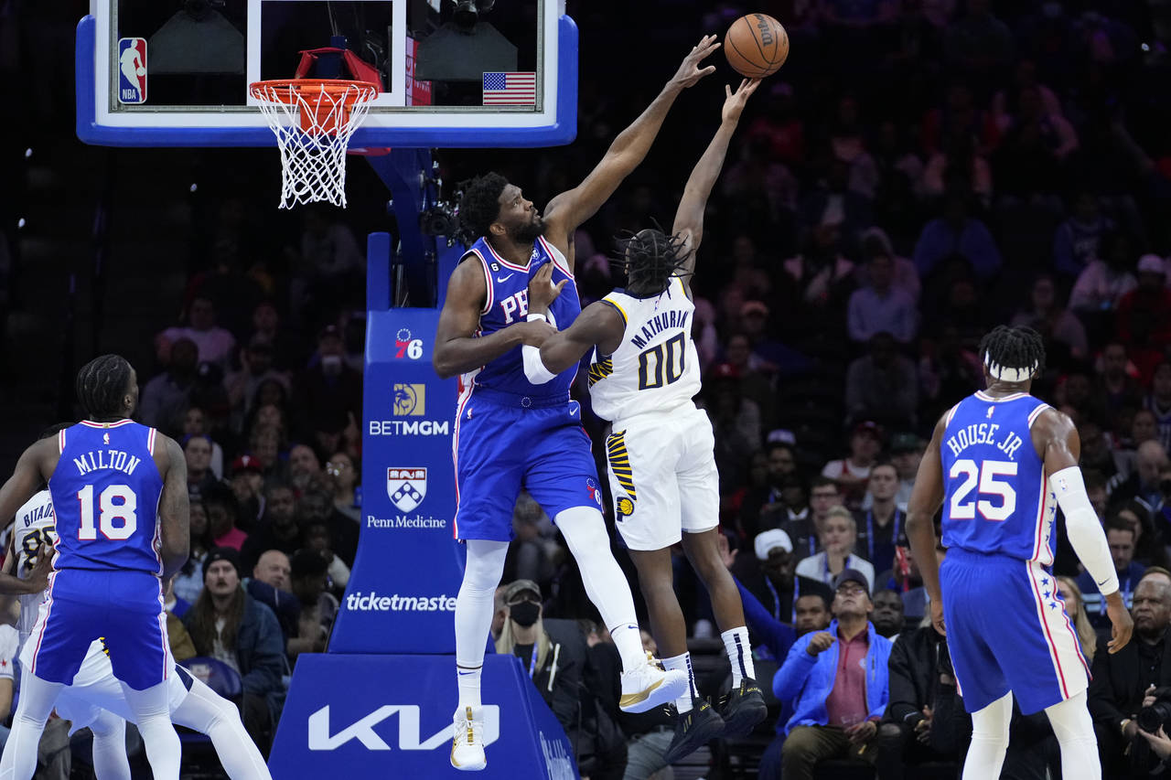 Philadelphia 76ers' Joel Embiid, left, blocks a shot by Indiana Pacers' Bennedict Mathurin during t...