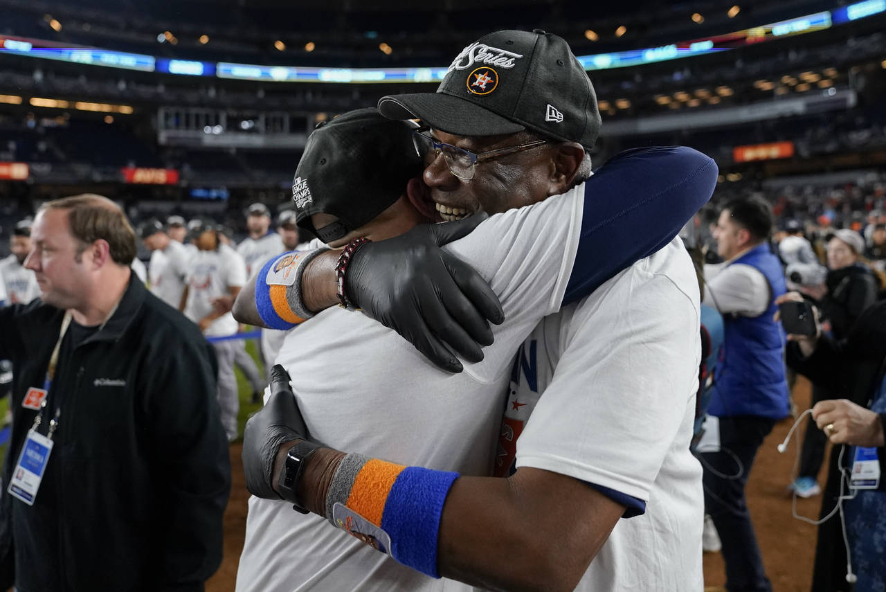 Houston Astros manager Dusty Baker Jr. left, celebrates with the team on the field after defeating ...