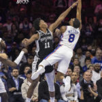 
              Philadelphia 76ers guard De'Anthony Melton (8) takes a shot over San Antonio Spurs guard Joshua Primo (11) in the first half of an NBA basketball game, Saturday, Oct. 22, 2022, in Philadelphia. (AP Photo/Laurence Kesterson)
            
