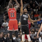 
              Chicago Bulls forward DeMar DeRozan (11) shoots over San Antonio Spurs forward Keita Bates-Diop (31) to score his 20,000th career point during the first half of an NBA basketball game, Friday, Oct. 28, 2022, in San Antonio. (AP Photo/Nick Wagner)
            