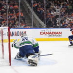 
              Vancouver Canucks goalie Thatcher Demko (35) gives up a goal to Edmonton Oilers' Darnell Nurse (25) during the second period of an NHL hockey game Wednesday, Oct. 12, 2022, in Edmonton, Alberta. (Jason Franson/The Canadian Press via AP)
            